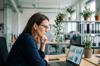 Femme en bureau moderne analysant des graphiques colorés