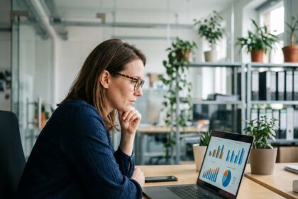 Femme en bureau moderne analysant des graphiques colorés