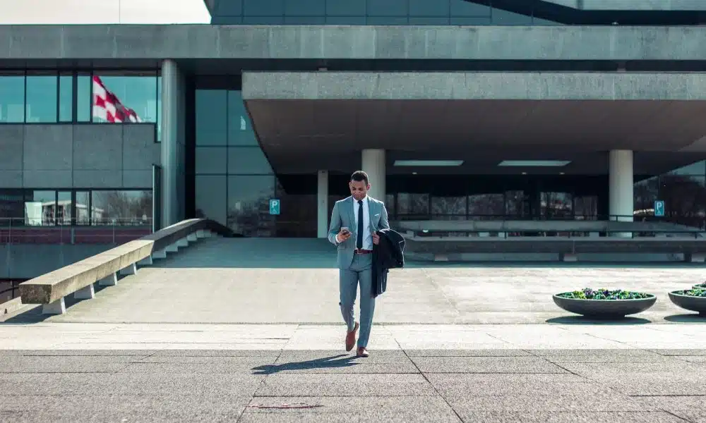 man walking while holding black coat