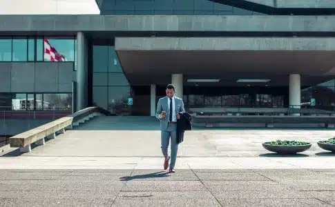 man walking while holding black coat